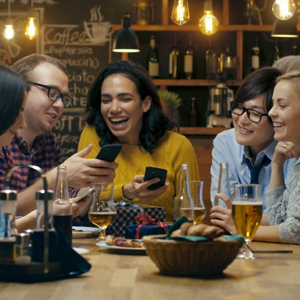 Friends at table looking at phone