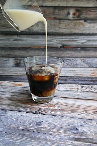 Cream being poured into cold brew cofee