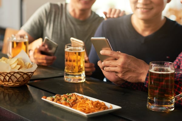 Men on phones at bar