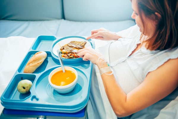 Hospital patient eating food from cafeteria tray