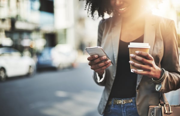 Woman holding phone and coffee